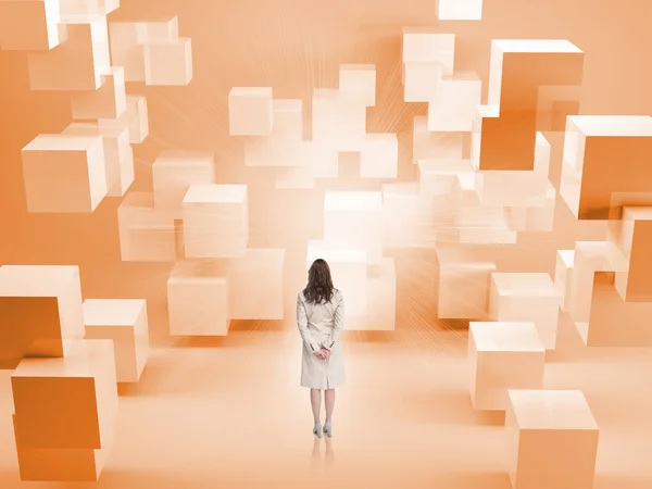Rückansicht einer Geschäftsfrau, die in einem Raum mit orangefarbenen Blöcken steht — Stockfoto