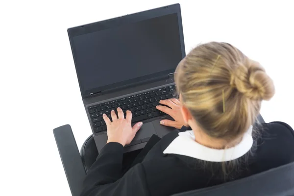 Visão traseira de empresária sentada em cadeira giratória usando laptop — Fotografia de Stock
