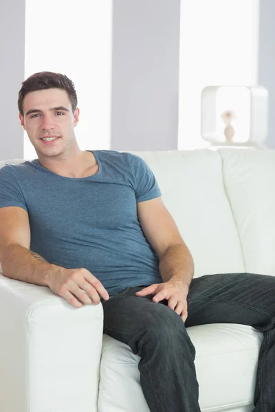 Sonriente guapo casual hombre relajarse en el sofá —  Fotos de Stock