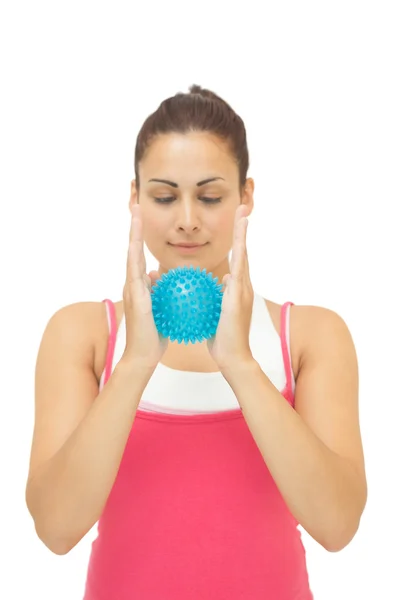 Uśmiechający się sportowy brunetka gospodarstwo masaże niebieski piłka między ręce — Zdjęcie stockowe