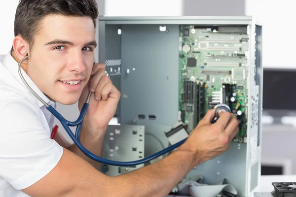 Engenheiro de informática sorrindo examinando hardware com estetoscópio — Fotografia de Stock