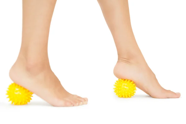 Close up van vrouwelijke voeten aanraken gele massage ballen — Stockfoto
