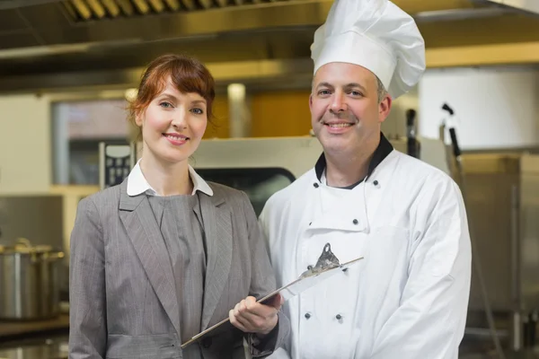 Maduro jefe de cocina posando con el gerente femenino — Foto de Stock