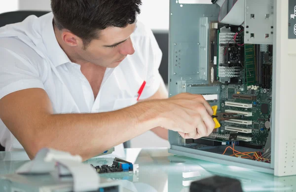 Knappe computer ingenieur computer herstellen met een tang — Stockfoto