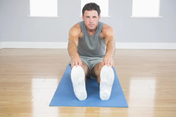 Attraktiv sportig man stretching benen — Stockfoto