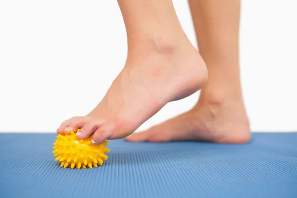 Close up de pés femininos tocando bola de massagem amarela — Fotografia de Stock