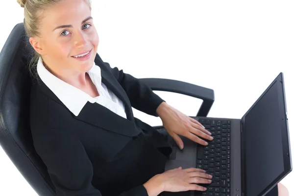 Feliz joven empresaria sentada en una silla de oficina usando su cuaderno —  Fotos de Stock