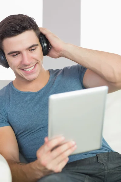Content handsome man using tablet listening to music — Stock Photo, Image