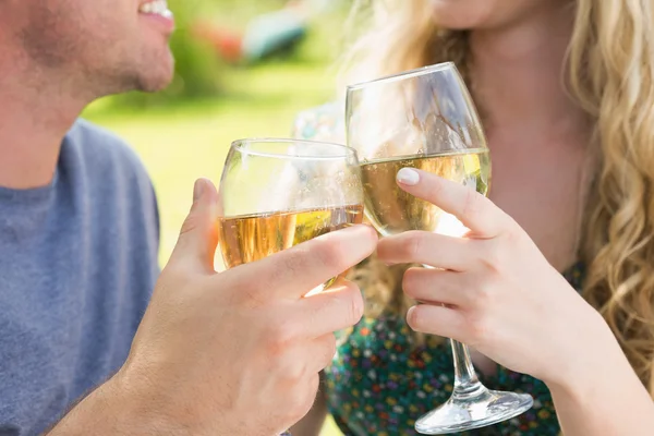 Lächelndes Paar stößt mit Weißwein an — Stockfoto