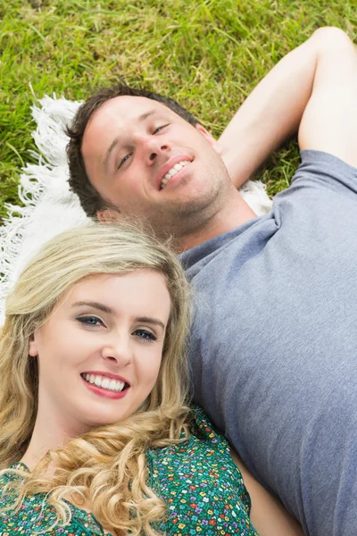 Smiling couple lying on a blanket — Stock Photo, Image