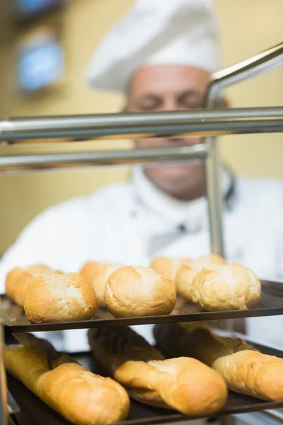 Mature baker pushing a trolley — Stock Photo, Image