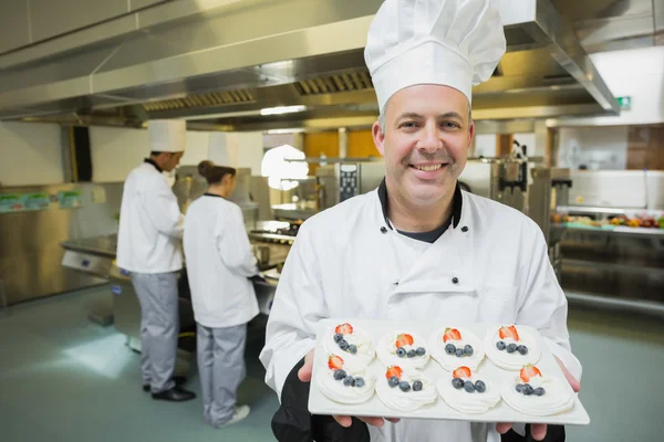 Gülümseyen Şef gururla sunan meringues tabak — Stok fotoğraf