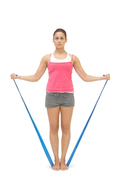 Serious sporty brunette exercising with resistance band — Stock Photo, Image