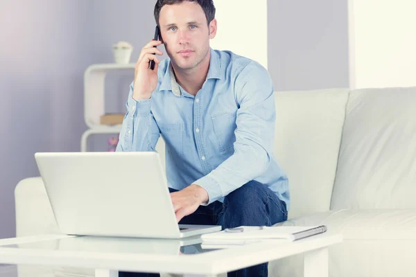 Content casual man using laptop and phoning — Stock Photo, Image