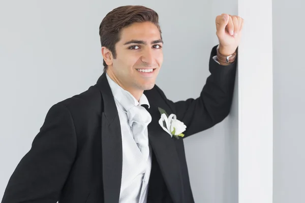 Schöner Bräutigam lehnt an einer Wand — Stockfoto