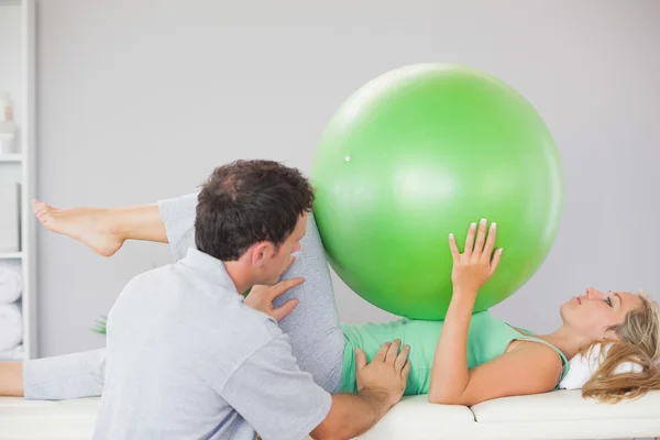 Patient holding exercise ball over chest — Stock Photo, Image
