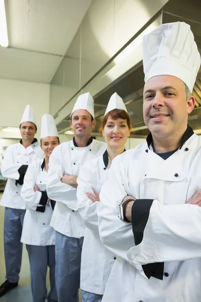 Команда щасливих кухарів посміхається в камеру — стокове фото