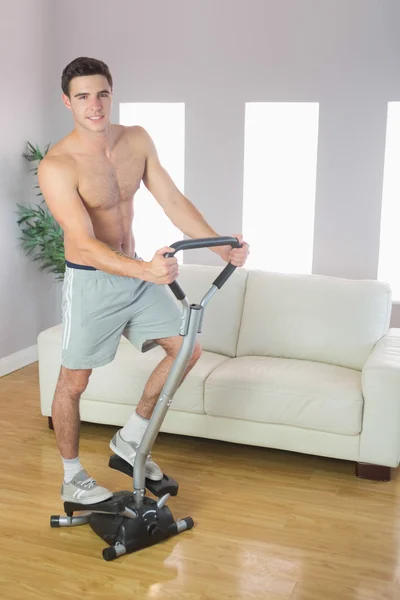 Smiling handsome man training on stair climber — Stock Photo, Image
