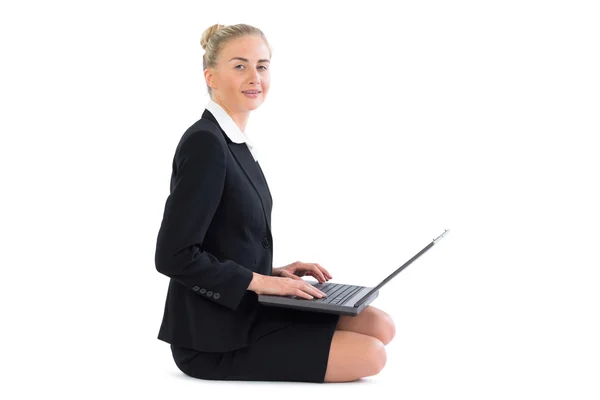 Adorável jovem empresária sentada no chão usando seu caderno — Fotografia de Stock