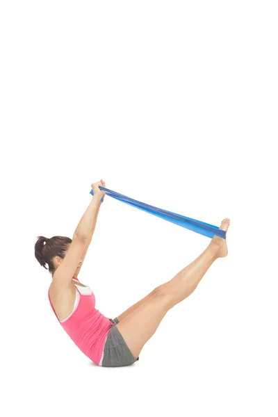 Attractive sporty brunette exercising with resistance band — Stock Photo, Image