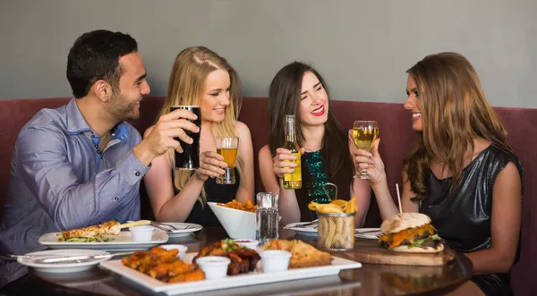 Szczęśliwy przyjaciółmi siedząc razem obiad — Zdjęcie stockowe
