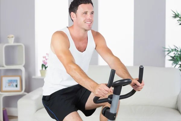 Content sporty man exercising on bike — Stock Photo, Image