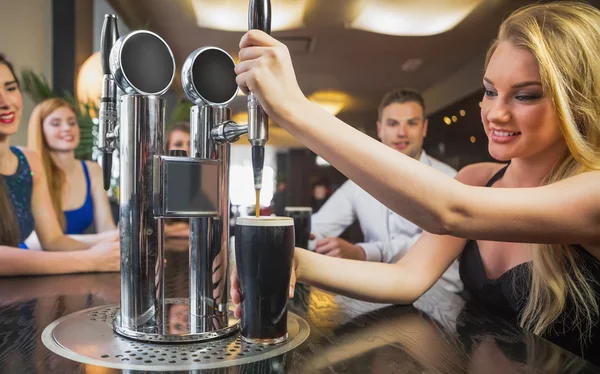 Atractiva mujer tirando de una pinta de cerveza — Foto de Stock