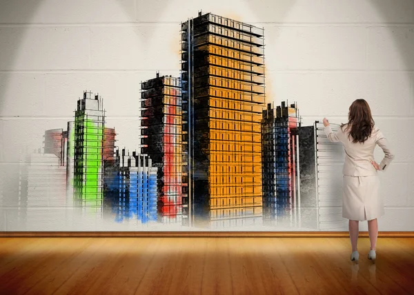 Geschäftsfrau malt bunte Stadt an Wand — Stockfoto