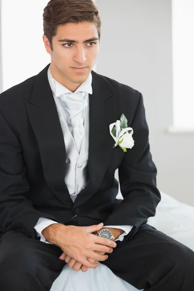 Junge hübsche Bräutigam sitzt auf Bett — Stockfoto