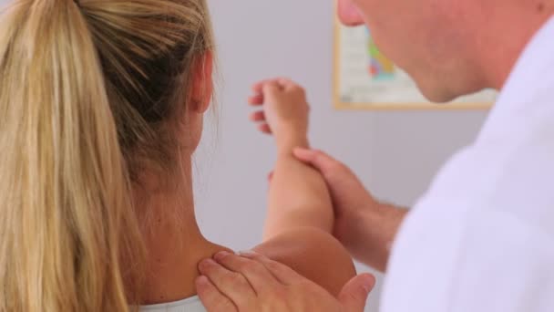 Fisioterapeuta manipulando el brazo de sus pacientes — Vídeo de stock