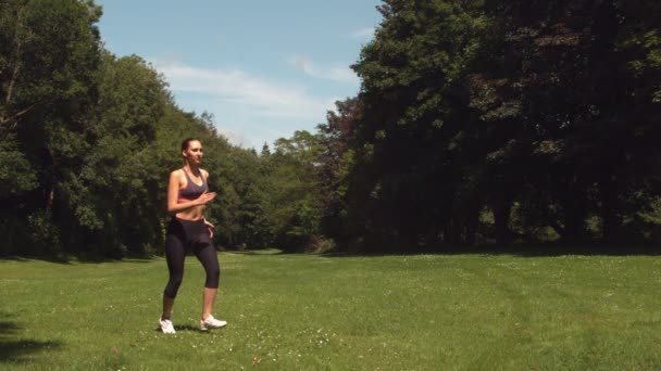 Brune sportive courir sur l'herbe — Video