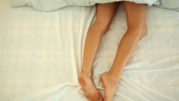 Female legs lying in bed — Stock Video