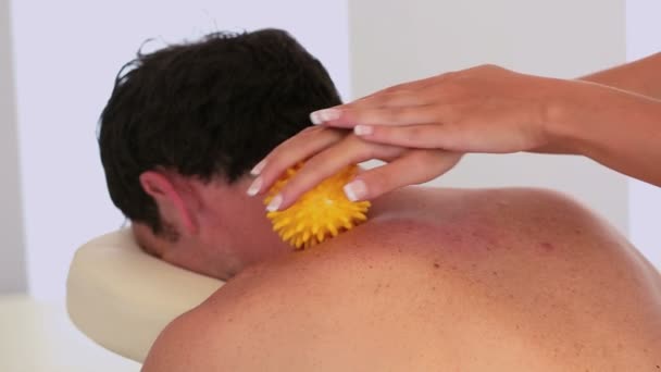 Massaggiatrice con palla da massaggio gialla sul collo dei clienti — Video Stock