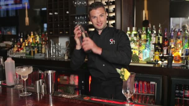 Guapo camarero sacudiendo bebida en una coctelera — Vídeo de stock