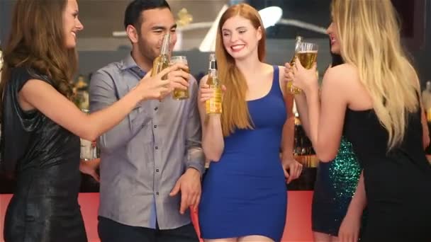 Amigos bem vestidos batendo suas garrafas enquanto fazem festa juntos — Vídeo de Stock