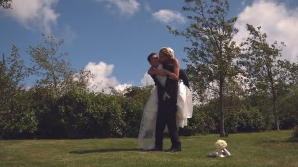 Happy groom carrying his bride on piggy back — Stock Video