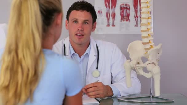 Chiropractor spreken met zijn patiënt — Stockvideo