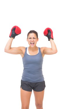 Excited sporty brunette wearing red boxing gloves clipart