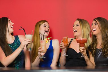 Laughing friends holding cocktails clipart