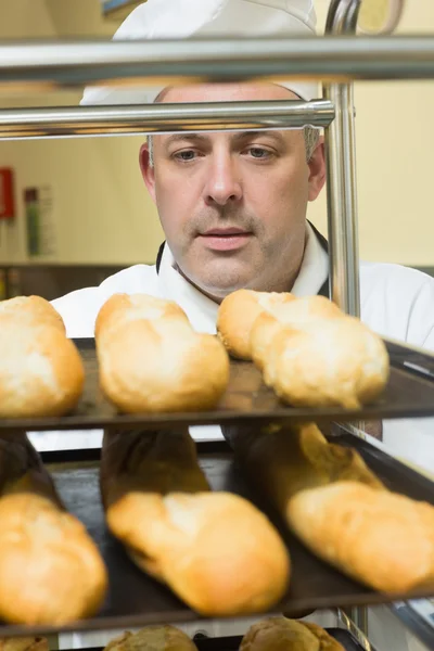 Head chef pushing a trolley with baguettes on it — Stock Photo, Image
