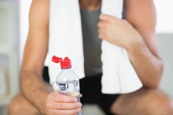 Närbild på vatten flaska innehas av sportig man med handduk — Stockfoto