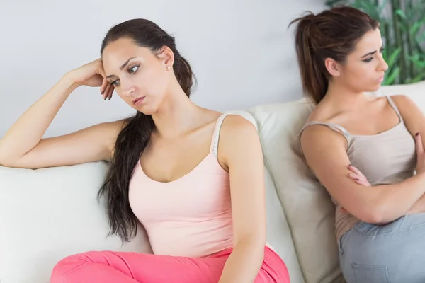 Dos hermosas mujeres peleando sentadas en un sofá — Foto de Stock