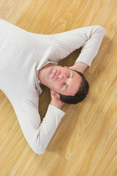 Casual uomo tranquillo sdraiato sul pavimento con gli occhi chiusi — Foto Stock
