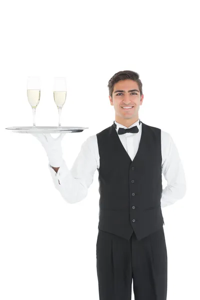 Kind young waiter presenting a silver tray — Stock Photo, Image