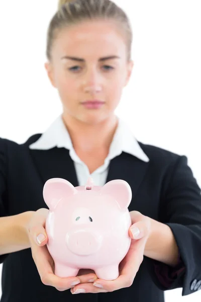 Ernstige jonge zakenvrouw houden van roze piggy bank — Stockfoto