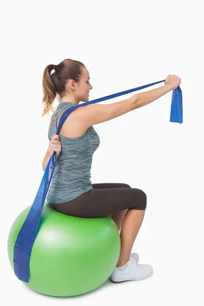 Cute woman stretching her arms with a resistance band — Stock Photo, Image