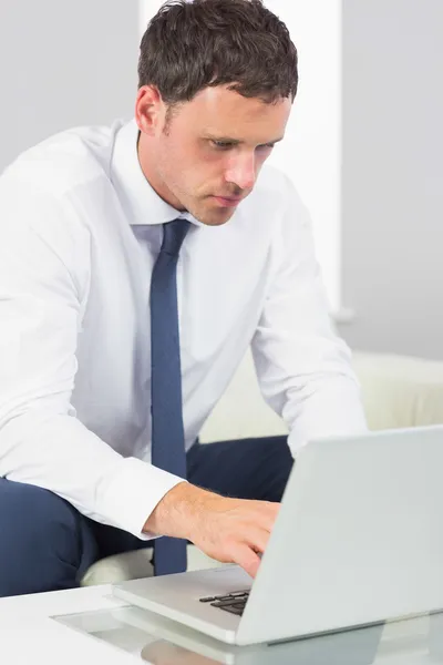 Ernstige knappe zakenman die op laptop werkt — Stockfoto