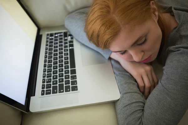 Zrzka spí na gauči s její laptop — Stock fotografie