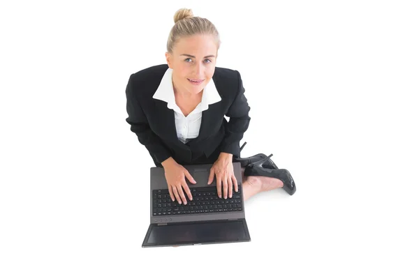 Smiling young businesswoman sitting on floor — Stock Photo, Image