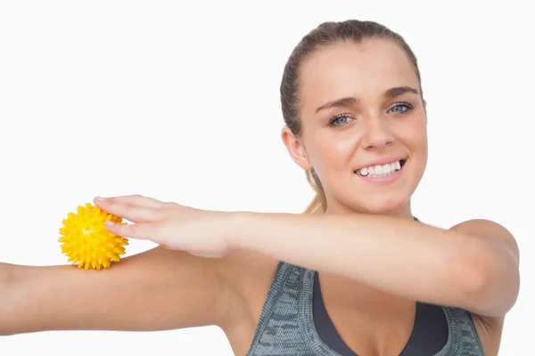 Allegro giovane donna toccando braccio con palla da massaggio — Foto Stock